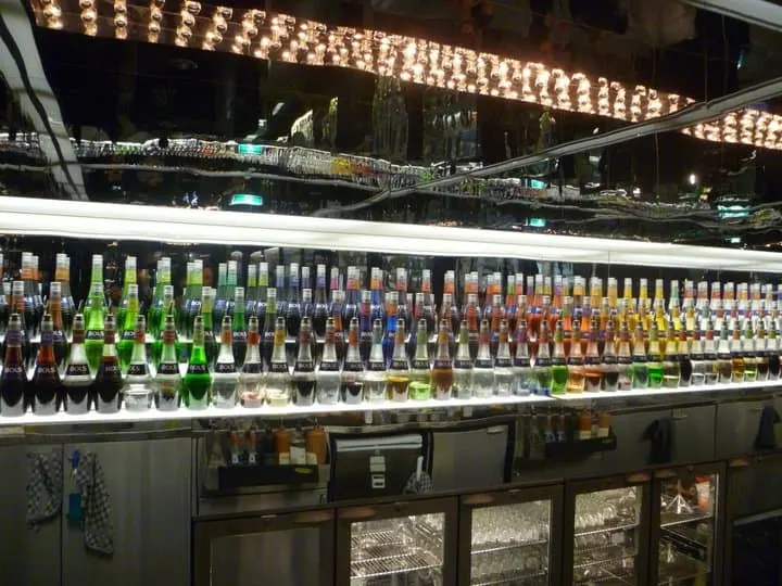 Bar Area in House of Bols Museum with mirrored back bar with lines of coulourful cocktail liquers lined up in front of it