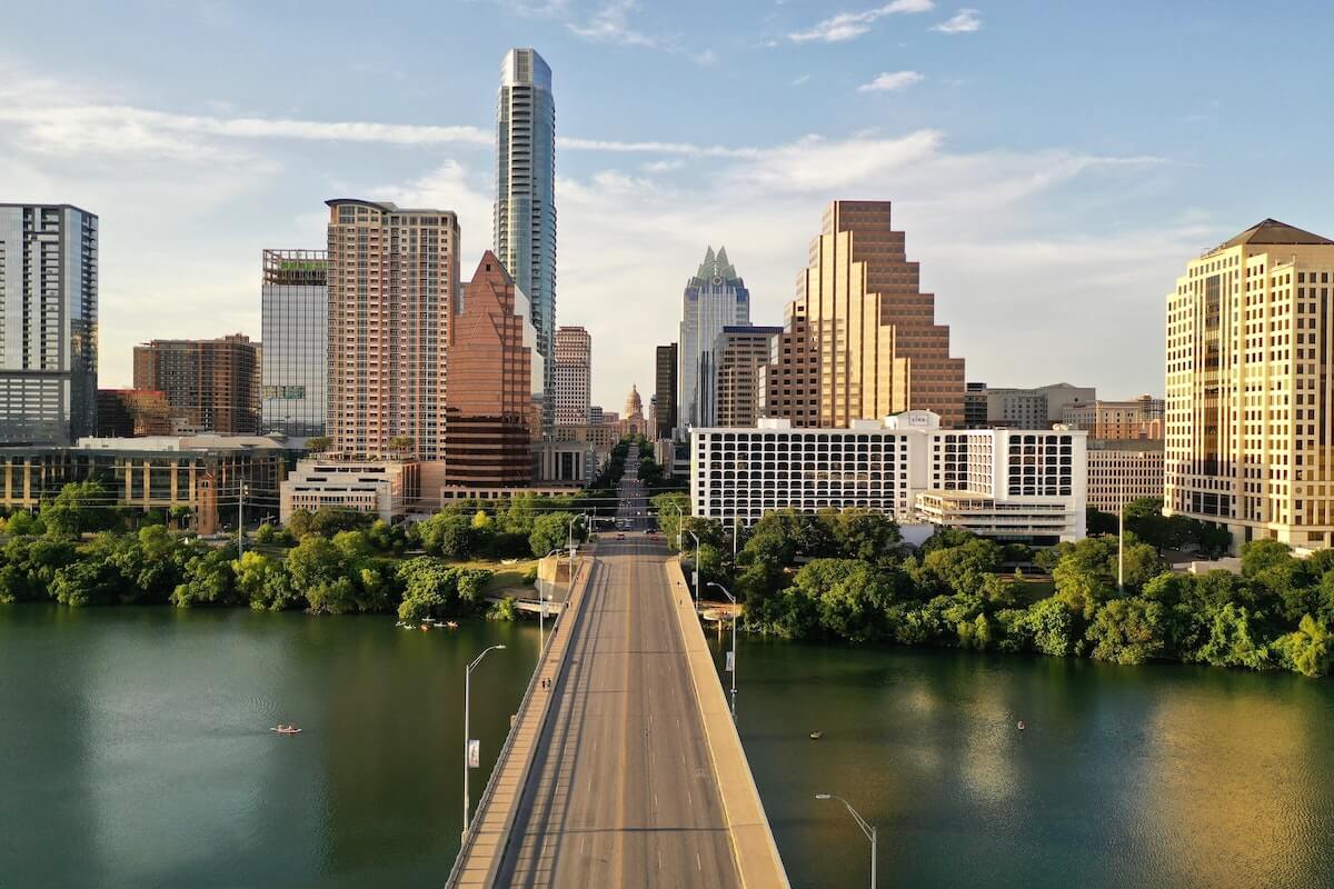 48 Hours in Austin Texas cover photo of the skyline as viewed from above, a bridge over the river leading to the central part of the city