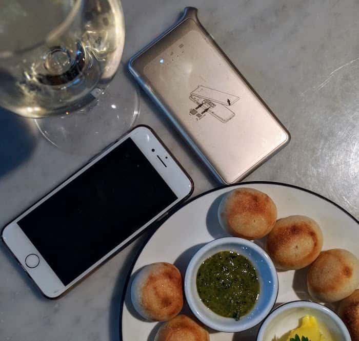 Pocket wifi with mobile phone, plate of food and glass of wine