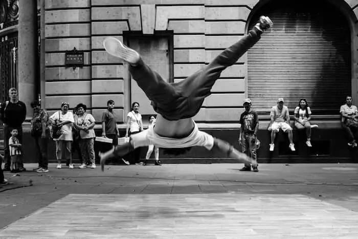 Black and white photographer of an acrobat on the street in mid-air