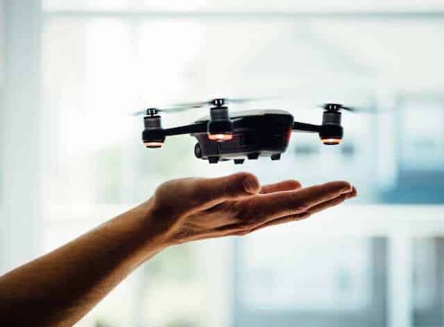 Top 10 Drone Accessories - Hand underneath a switched on drone