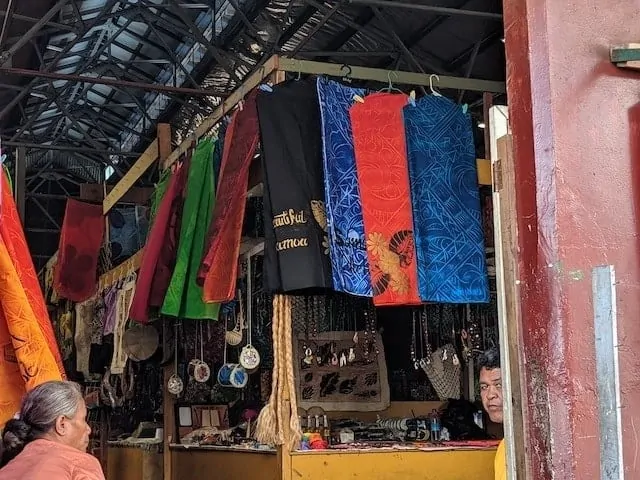 Market stall in Samoa with trinkets and jewellery hanging alongside fabrics and dresses