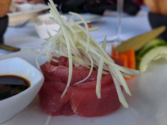 Tuna Sashimi in focus next to soy sauce and wasabi in the background
