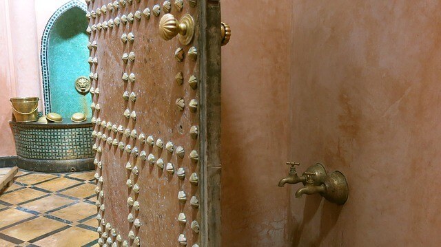 Open door to a hamman in Marrakech where you can see the buckets and taps used for the treatment