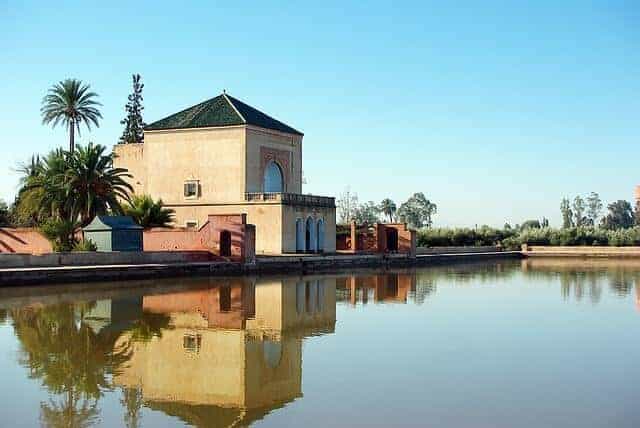 Menara Palace Pavillion in front of a completely still body of water with the building reflected.