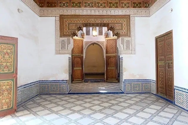 A room in the Bahia Palace with a tiled mosaic floor and ceiling, wooden doors in a traditional arched frame