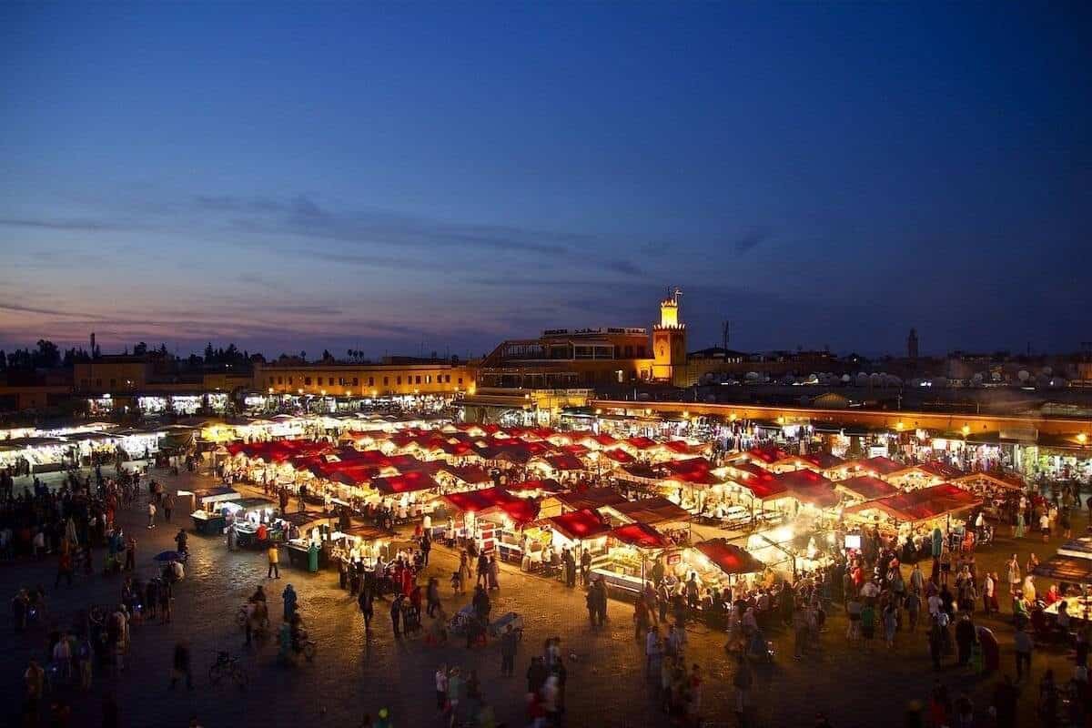 Things to do in Marrakech header image - view over the market square at night with the tents lit up and surrounded by people