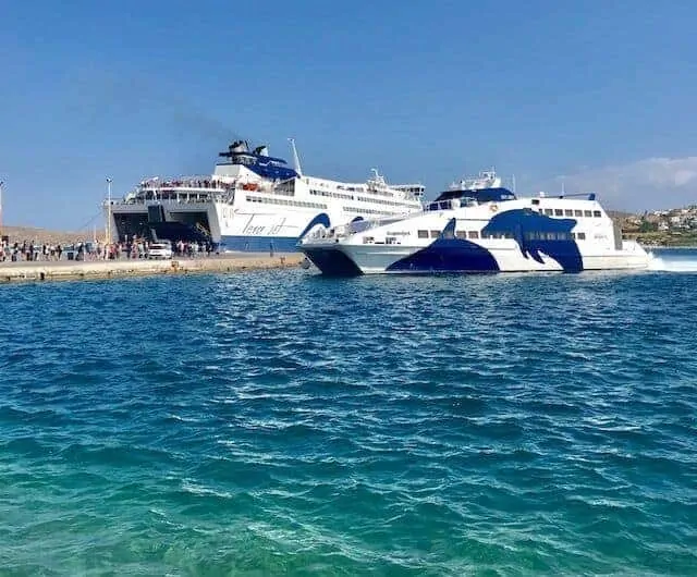 Two ferries parked facing opposite directions at the port surrounded by clear blue water