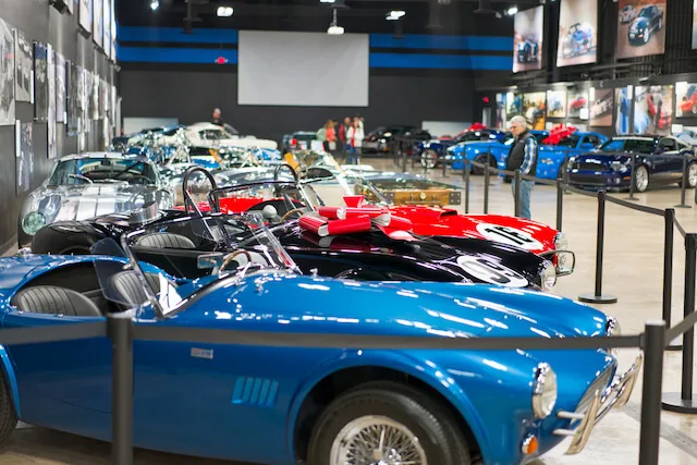 Vintage cars parked up in an indoor display, roped off to visitors at the Shelby American Heritage Center