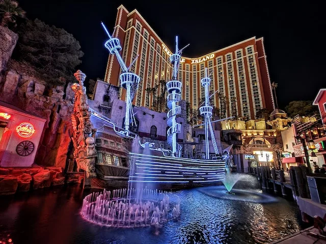 Pirate Ship lit up at night in front of Treasure Island hotel and Casino