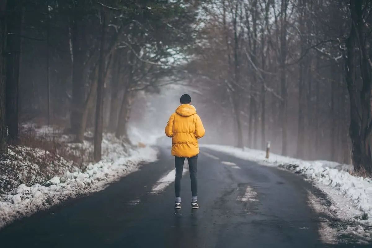 Best Packable Rain Jackets for Travel Cover Image of Man stood facing away from the caemra in a yellow jacket