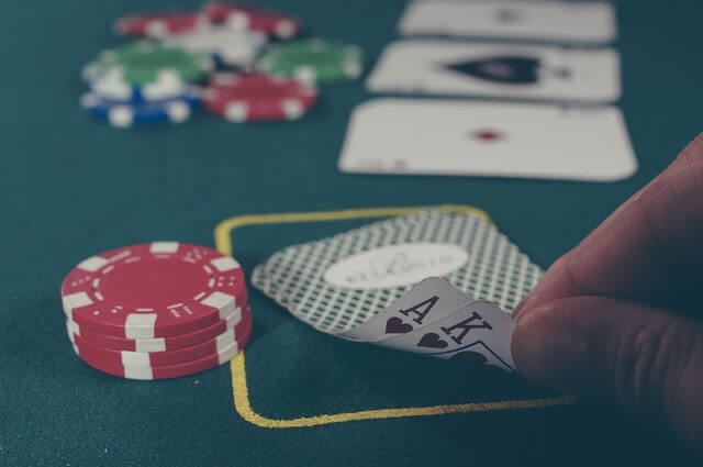Cards on a poker table next to colourful casino chips