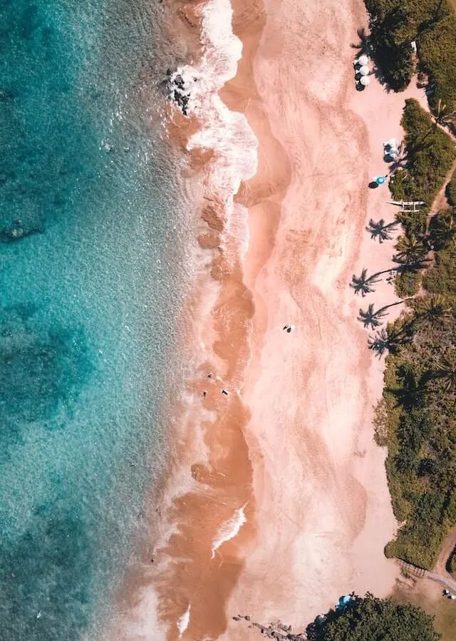 Maui beach from above, pink sand meeting the turquoise ocean