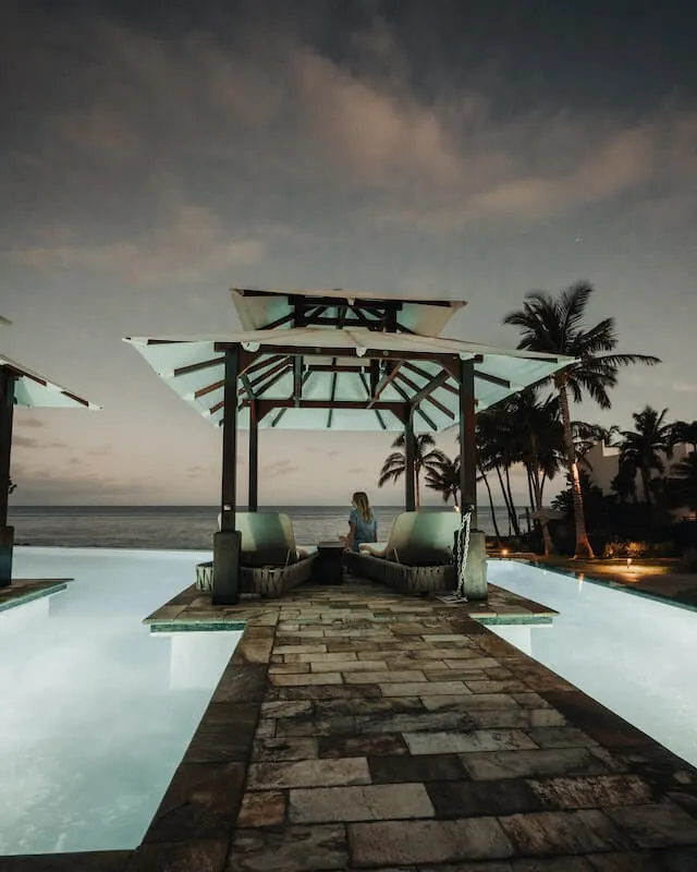 Woman sitting under a pergola in a luxury beachfront resort in Maui