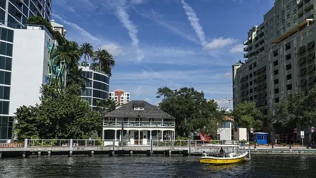 Old white plantation style house on the edge of the river