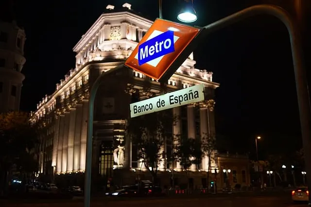 Metro Station at night in front of a white building lit up multiple uplights