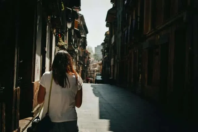 Single female traveler walking down a narrow street