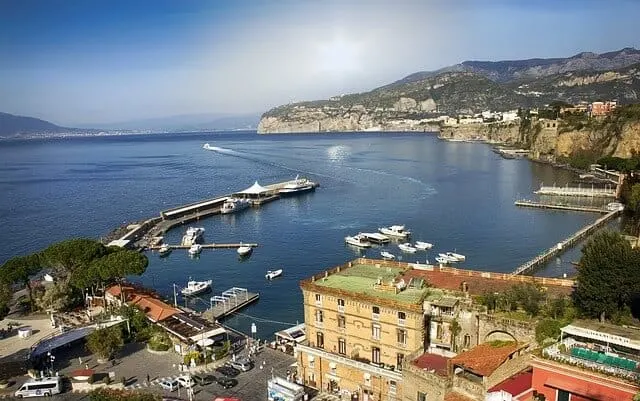 Looking out over the port of Sorrento with boats in the harbour and land in the distance
