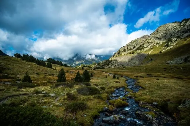 Beautiful view of the green mountains of the Pyrenees with a river running towards the camera