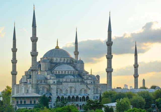 The impressive domed buildings of the Blue Mosque surrounded by 5 Minaret Towers from a distance at dusk