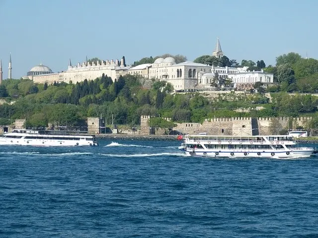 Topkapi Palace as seen from the Bosphorous River with the water in the foreground and the Palace raised up on the hill in the background