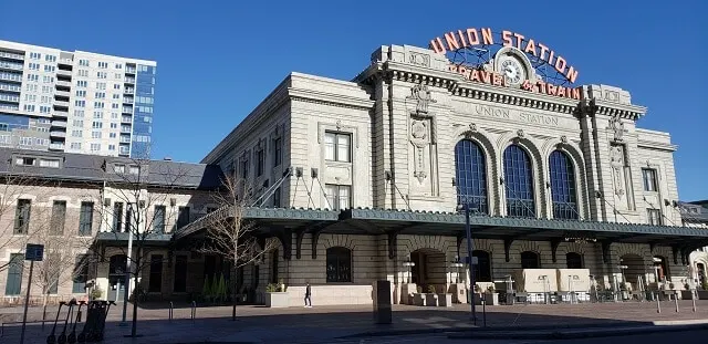 Large white building with 'Union Station Travel & Train' in giant red letters on top of the buidling under a blue sky