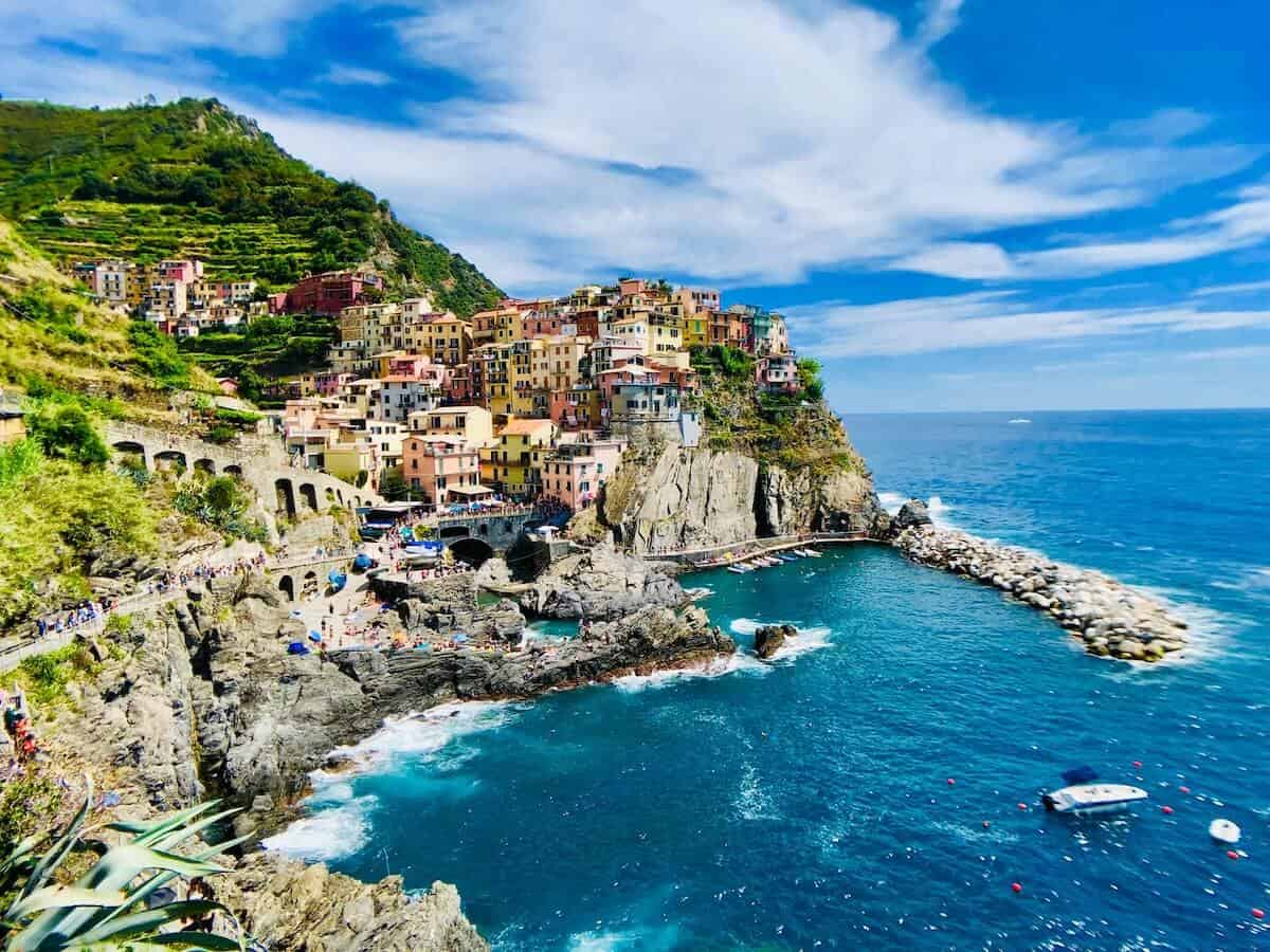 Header photo of Maranola village of colurful houses above a blue ocean and backed by the green hills for our Cinque Terre Tips and 3 Day Cinque Terre Itinerary