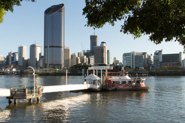 River with a pontoon leading to a docked City Ferry with skyscrapers in the background