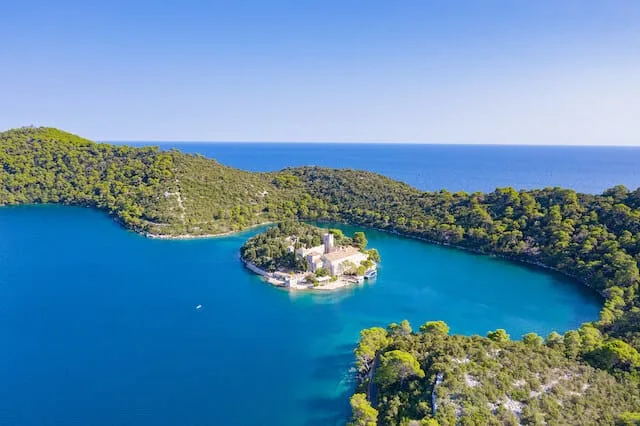 Aerial shot of lush green islands surrounded by turquoise blue waters of Mljet National Park in Croatia