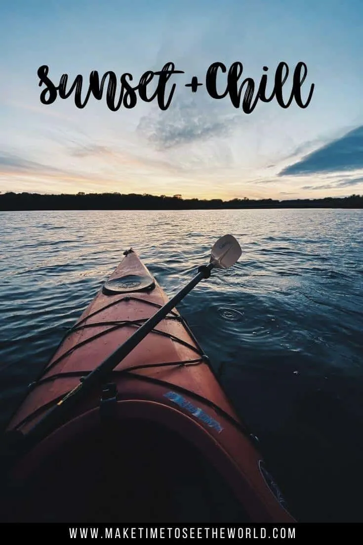 Sunset & Chill (text overlay) of a red kayak on the water with a paddle lying across the kayak