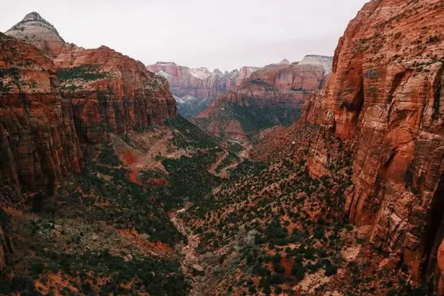 View down into the base of the valley from the Canyon Overlook trail. The rocks are red sandstone with a winding path through the centre and tress dotted around