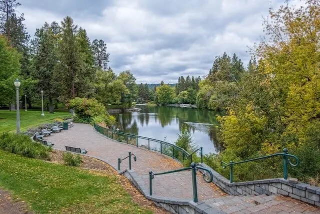 Park with a beige path surrounding a lake with trees all around