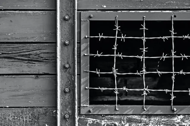 Black and white photo of a window covered in barbed wire bars at the Holocaust Museum El Paso