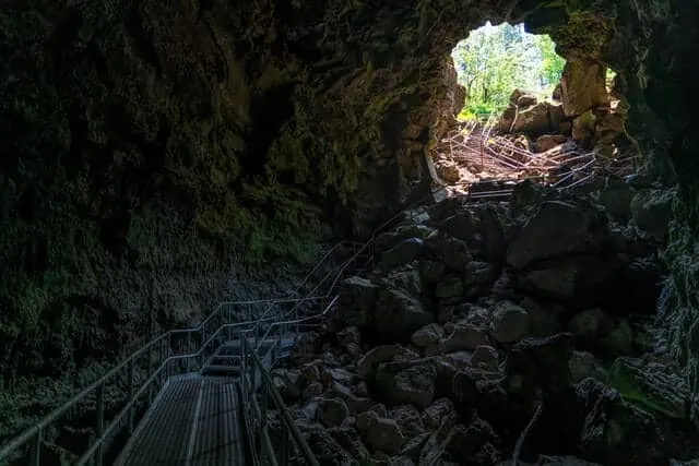 Inside a complex cave structure looking towards the domes entrance bathed in light with a metal walkway leading down to the bottom edge of the image