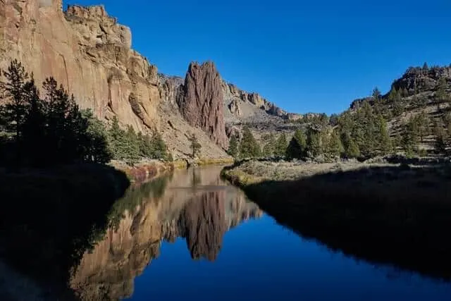 Large rocky crater with deep blue flat water lake at its base