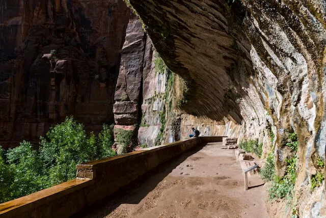 Rock overhand next to a walled pathway