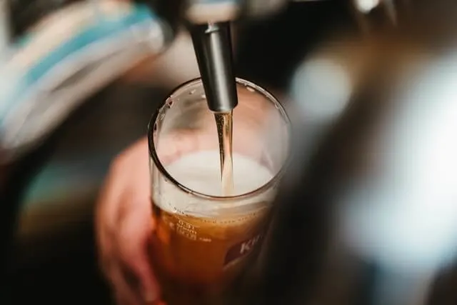 Hands pouring a beer from a spout on the Beer City Ale Trail Grand Rapids