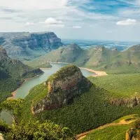 Best Time to Visit South Africa cover photo of a river running through the Green covered South Africa Mountain range