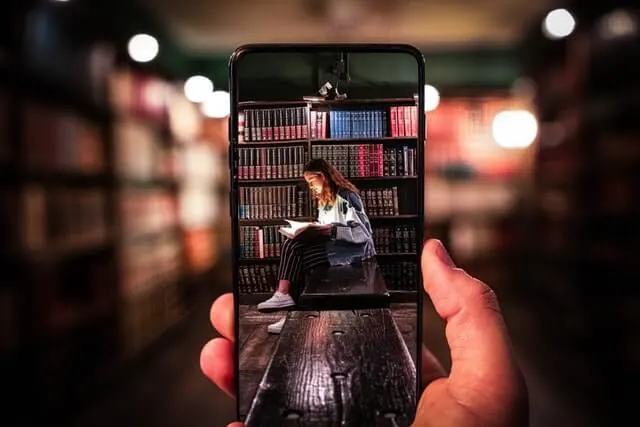 Woman sitting on a woman bench surrounded by books on shelves