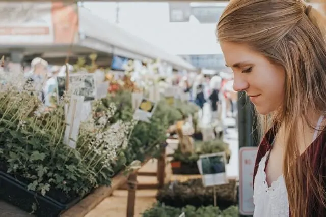 Woman looking at plants at a farmers market