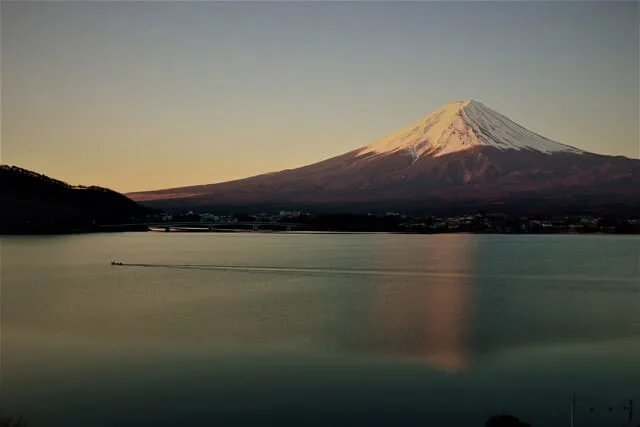 Still lake with a snow capped Mount Fuji in the background at sunrise