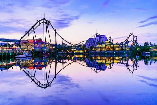 Unviseral Studios theme park at dusk, with rollercoasters rising in waves into the sky