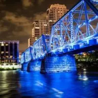 Fun things to do in Grand Rapids Michigan header photo of the blue bridge lit up in blue lights at night