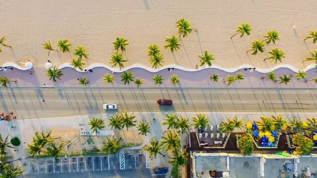 Top down shot of a beach, the road next to it and the buildings opposite the beach