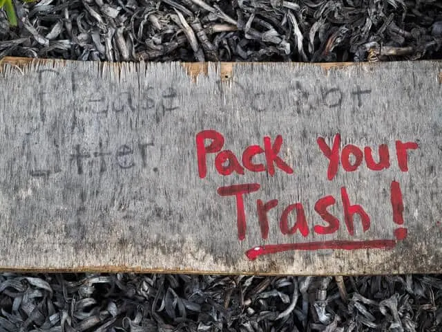 Wooden sign that says: Please do not litter and in bright red text "pack your Trash"