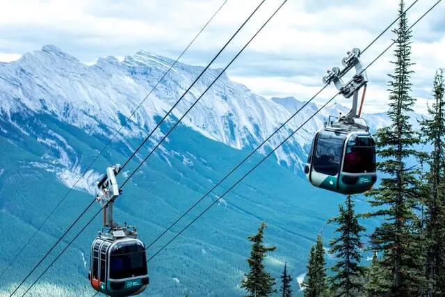 Banff Gondola carriages passing each other with the mountains in the background