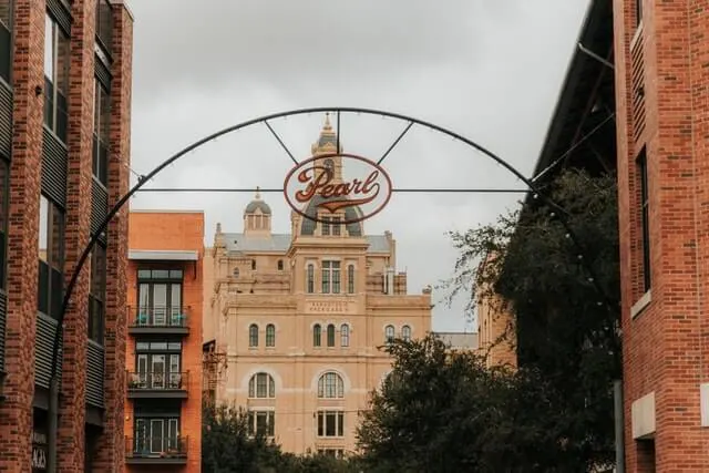 Pear District sign over the street with the Pearl Brewery building in the background