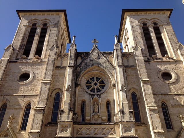 Facade of San Fernando Cathedral with two bell toers at each side with a stained glass circle in the centre