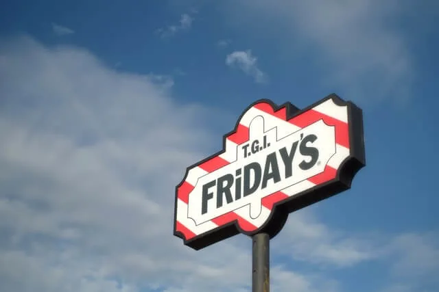 TGI Fridays sign on a tall pole against a blue sky