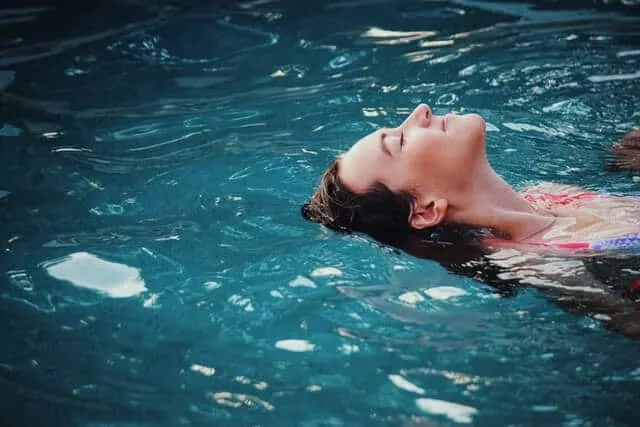 Woman's head and neck relaxing floating in a swimming pool